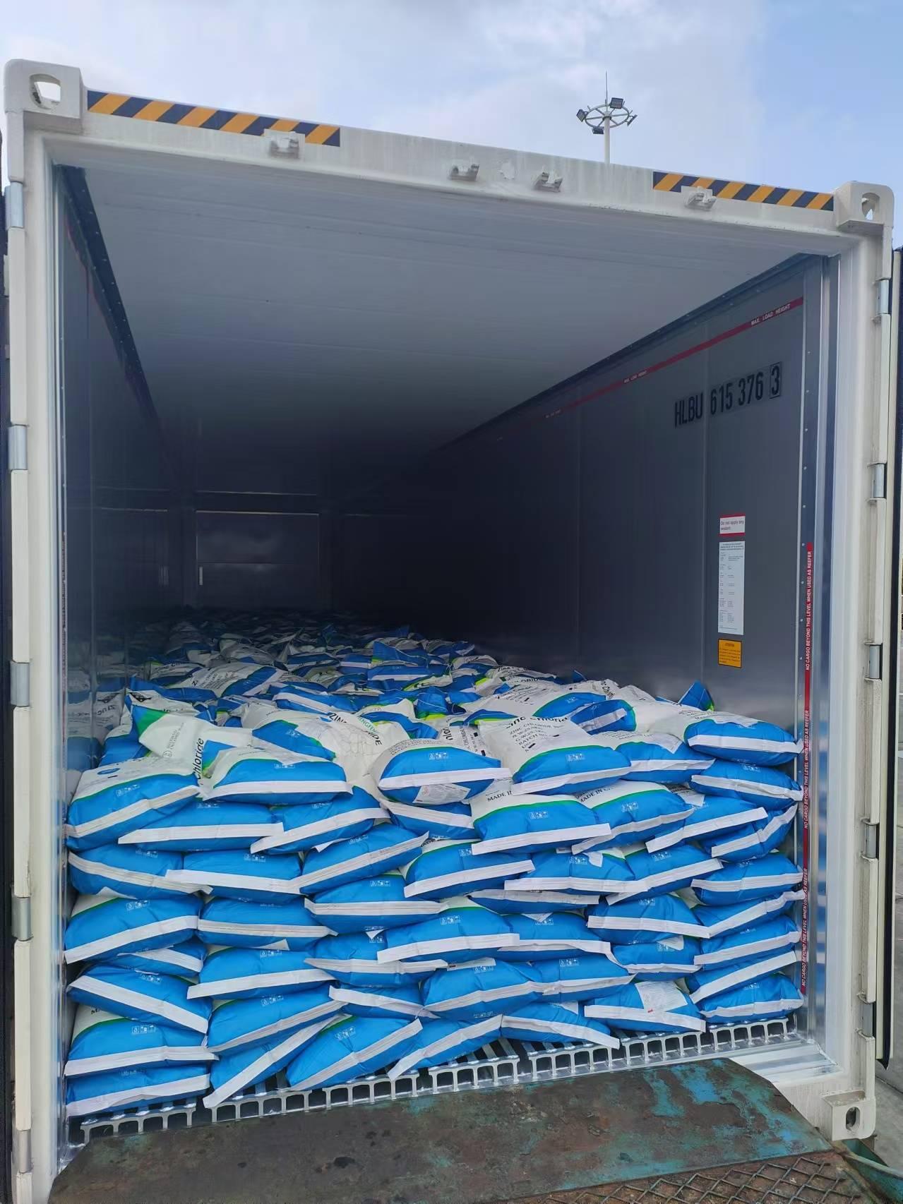 Open shipping container filled with stacked bags of zinc chloride