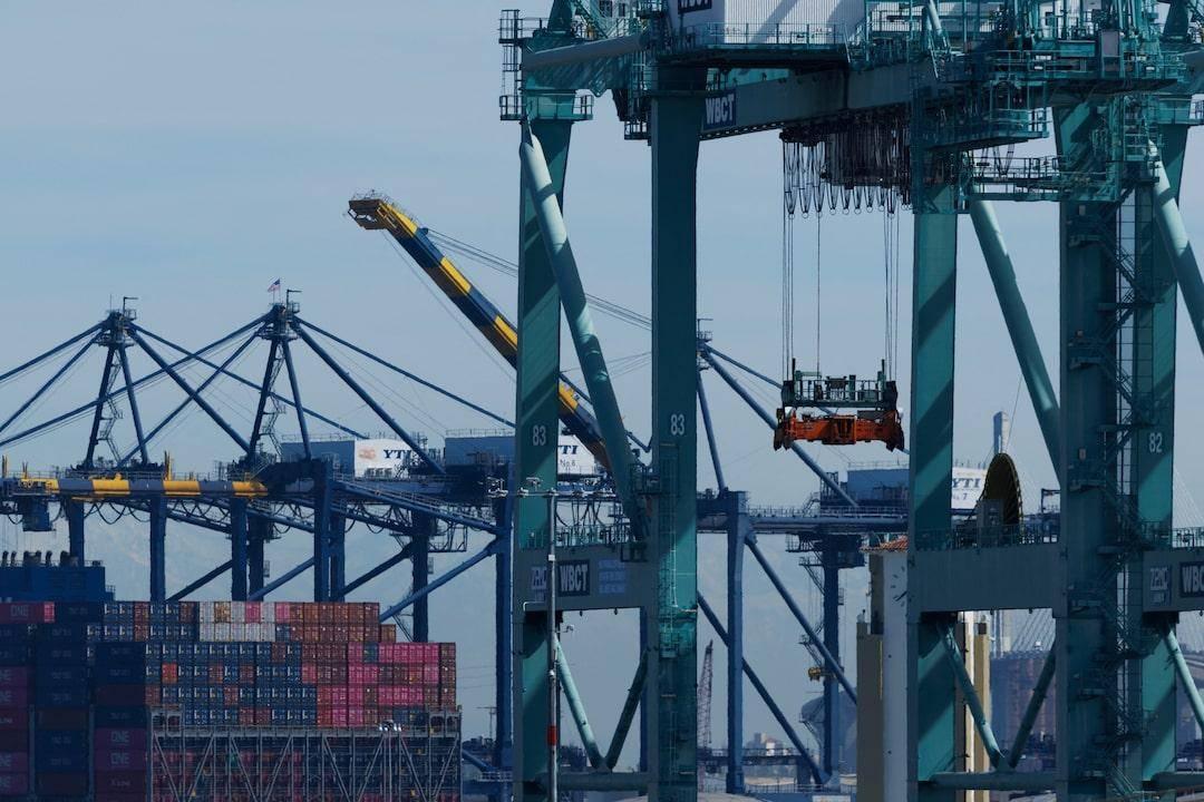 Port workers overseeing the loading of chemical containers