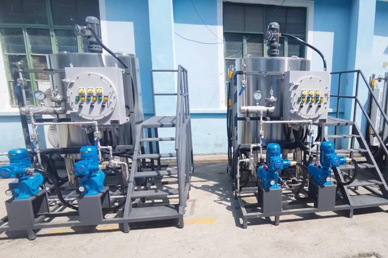 Stainless steel chemical dosing skid with blue pumps in an industrial setting