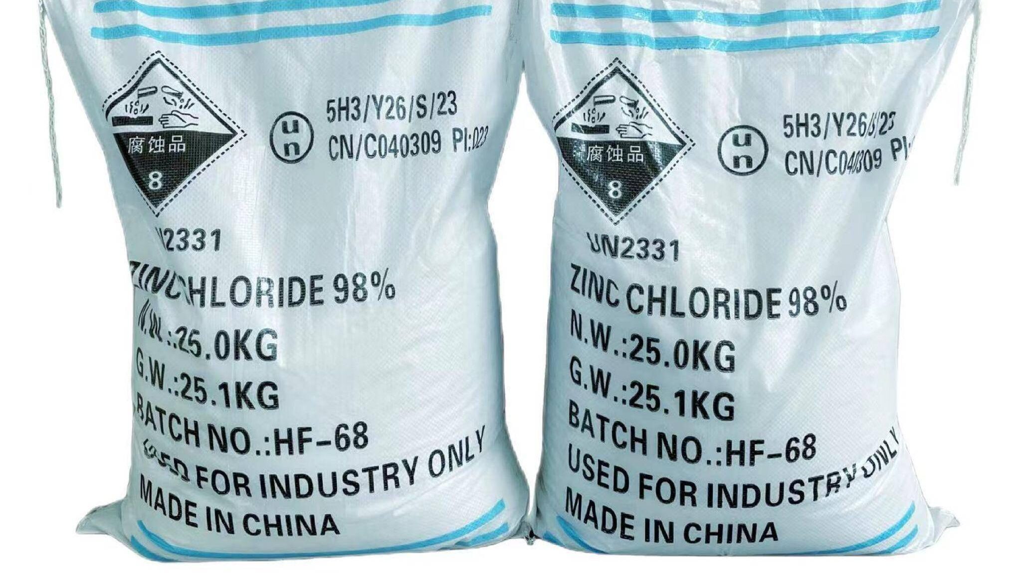 Two white 25kg bags of 98% zinc chloride with clear hazard labels and specifications
