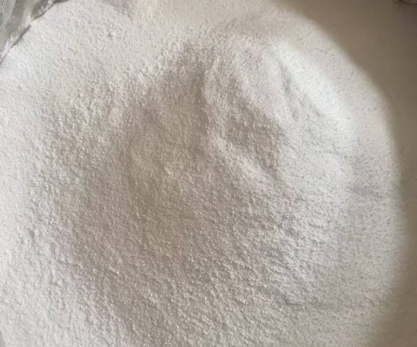 Close-up view of fine white anhydrous zinc chloride powder in a large industrial container