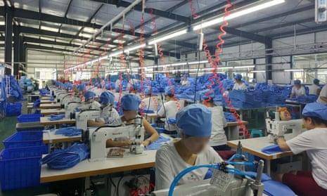 A faceless view of a long row of automated textile machines in a brightly lit modern factory in China.