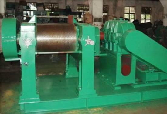  A faceless view of a large green industrial rubber creper and processing machine in a modern manufacturing facility.