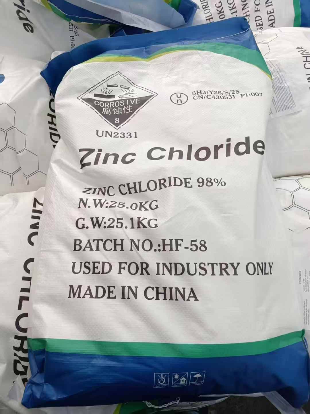 A faceless view of a large white industrial bag of zinc chloride anhydrous labeled for industrial and agricultural use.