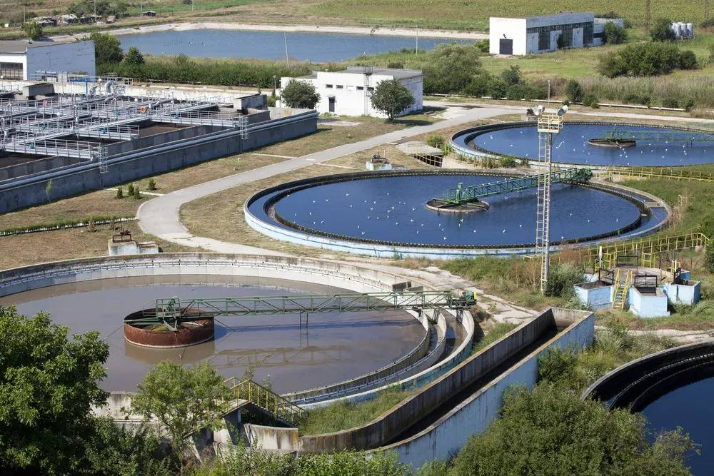 Vista aérea de una gran planta industrial de tratamiento de agua con tanques de sedimentación y balsas de aireación